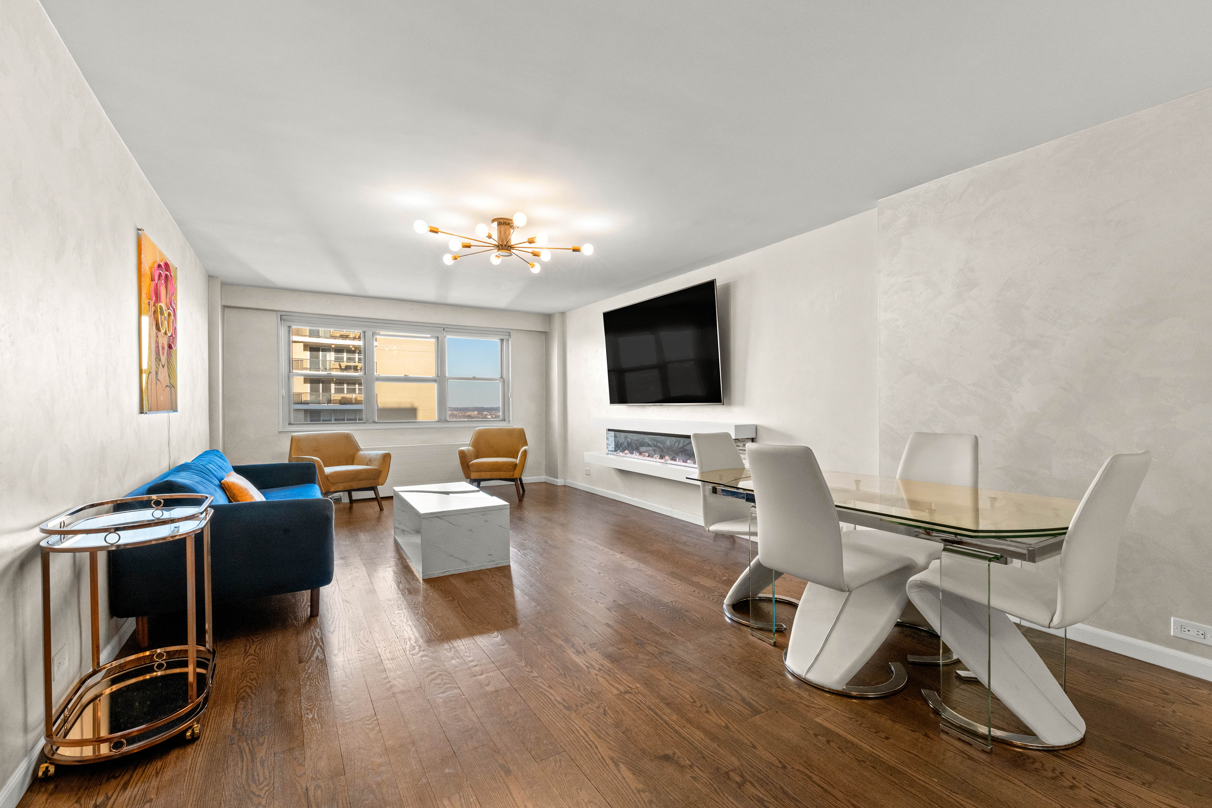 102-10 66th Road, Unit K25 Queens, NY 11375 - Photo 4 of 19 a living room with furniture a flat screen tv and wooden floor