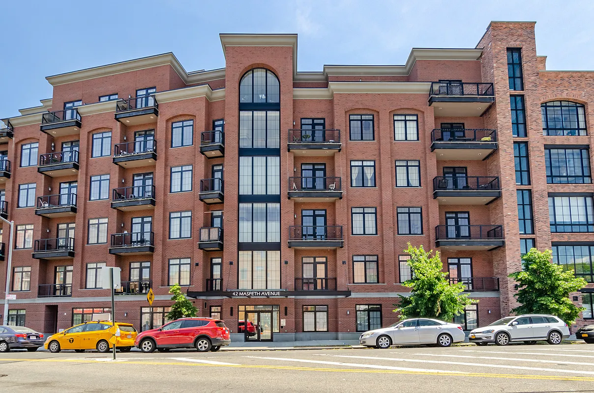 42 Maspeth Avenue, Unit 1B Brooklyn, NY 11211 - Photo 11 of 12 a front view of a building with lot of cars and trees