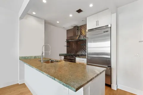 a kitchen with stainless steel appliances granite countertop a sink refrigerator and microwave