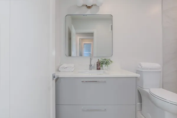 a bathroom with a sink a toilet and mirror