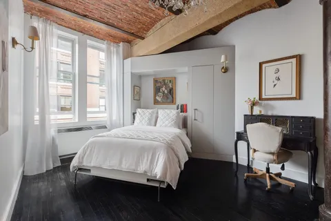 a bedroom with a bed a chair and a window