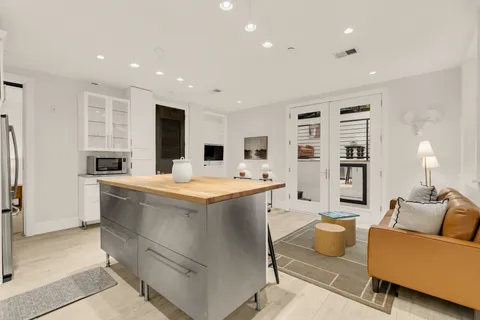 a large kitchen with stainless steel appliances kitchen island granite countertop a refrigerator and a stove top oven