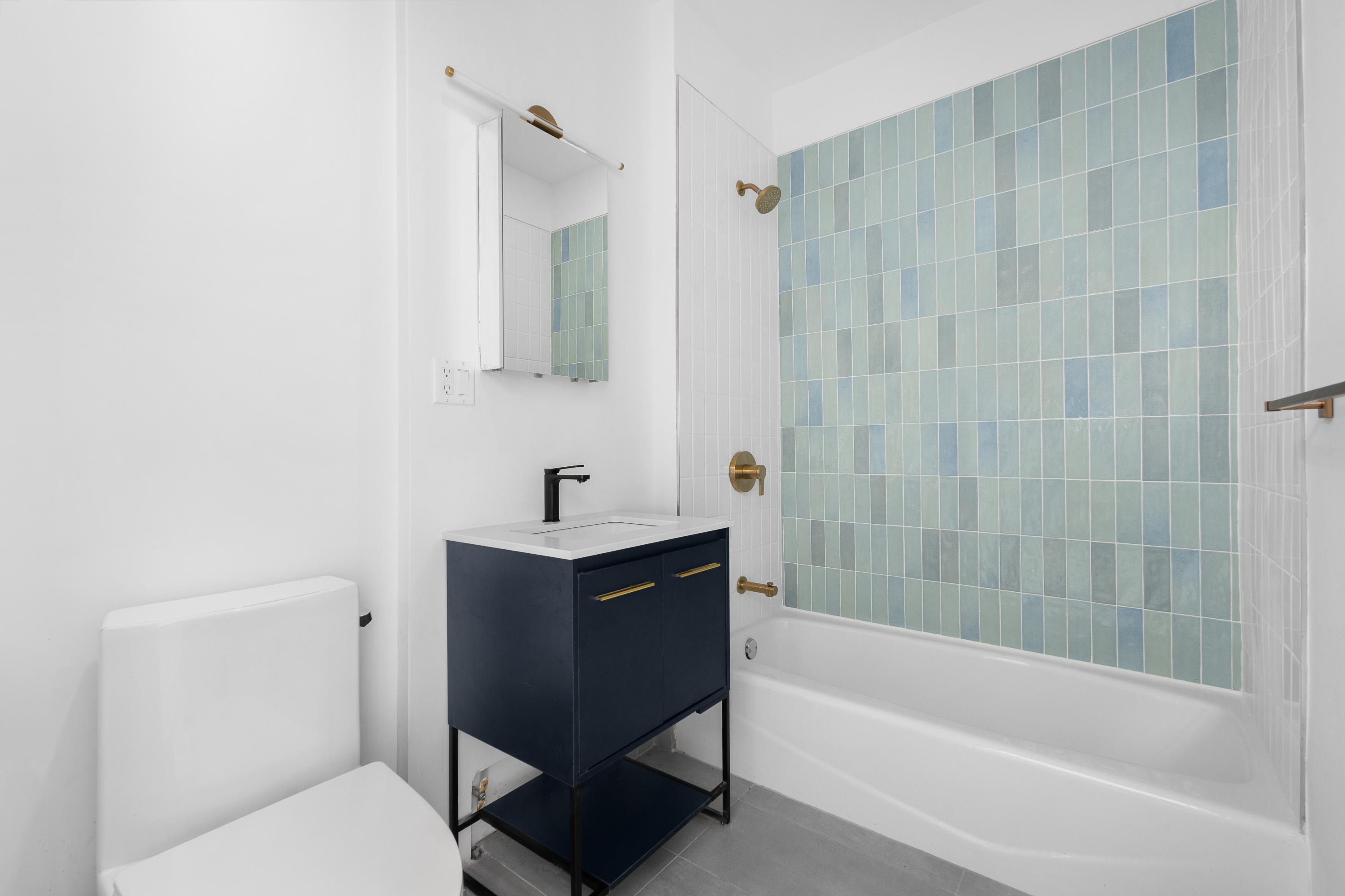 92 Wilson Avenue Brooklyn, NY 11237 - Photo 5 of 15 a bathroom with a bathtub a sink a toilet and a mirror