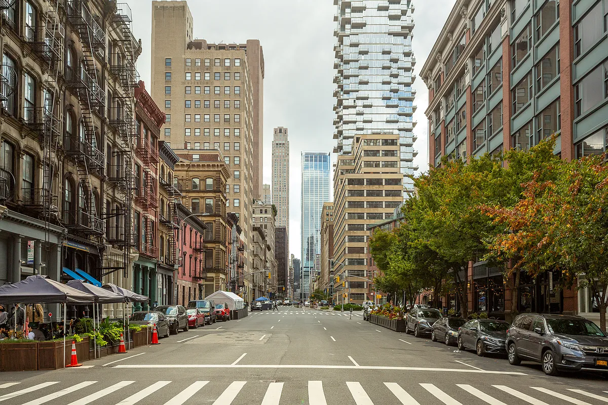 93 Worth Street, Unit 405 Manhattan, NY 10013 - Photo 10 of 18 a city street lined with buildings and cars