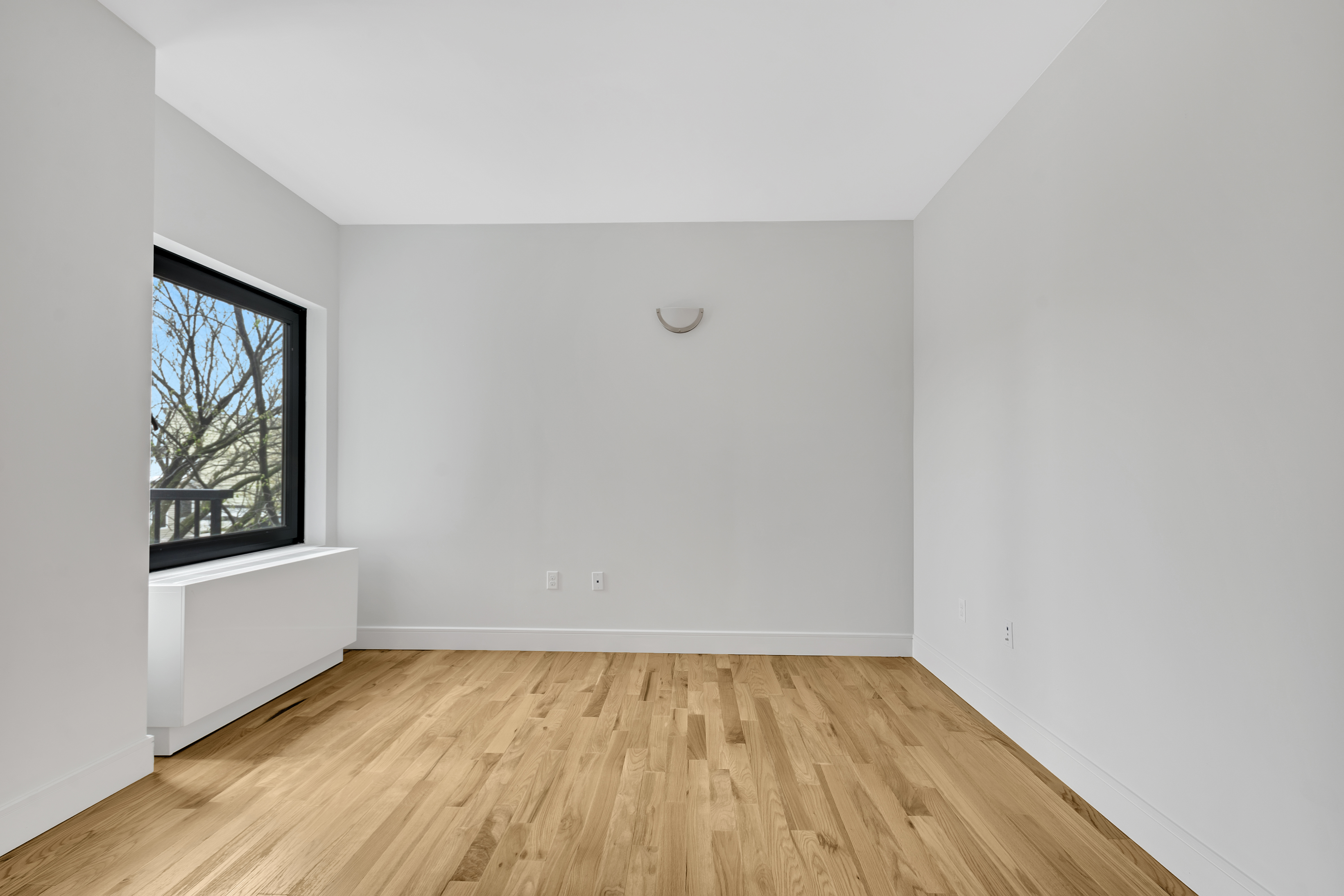 142 Richards Street, Unit 2E Brooklyn, NY 11231 - Photo 3 of 7 a view of an empty room with wooden floor and a window