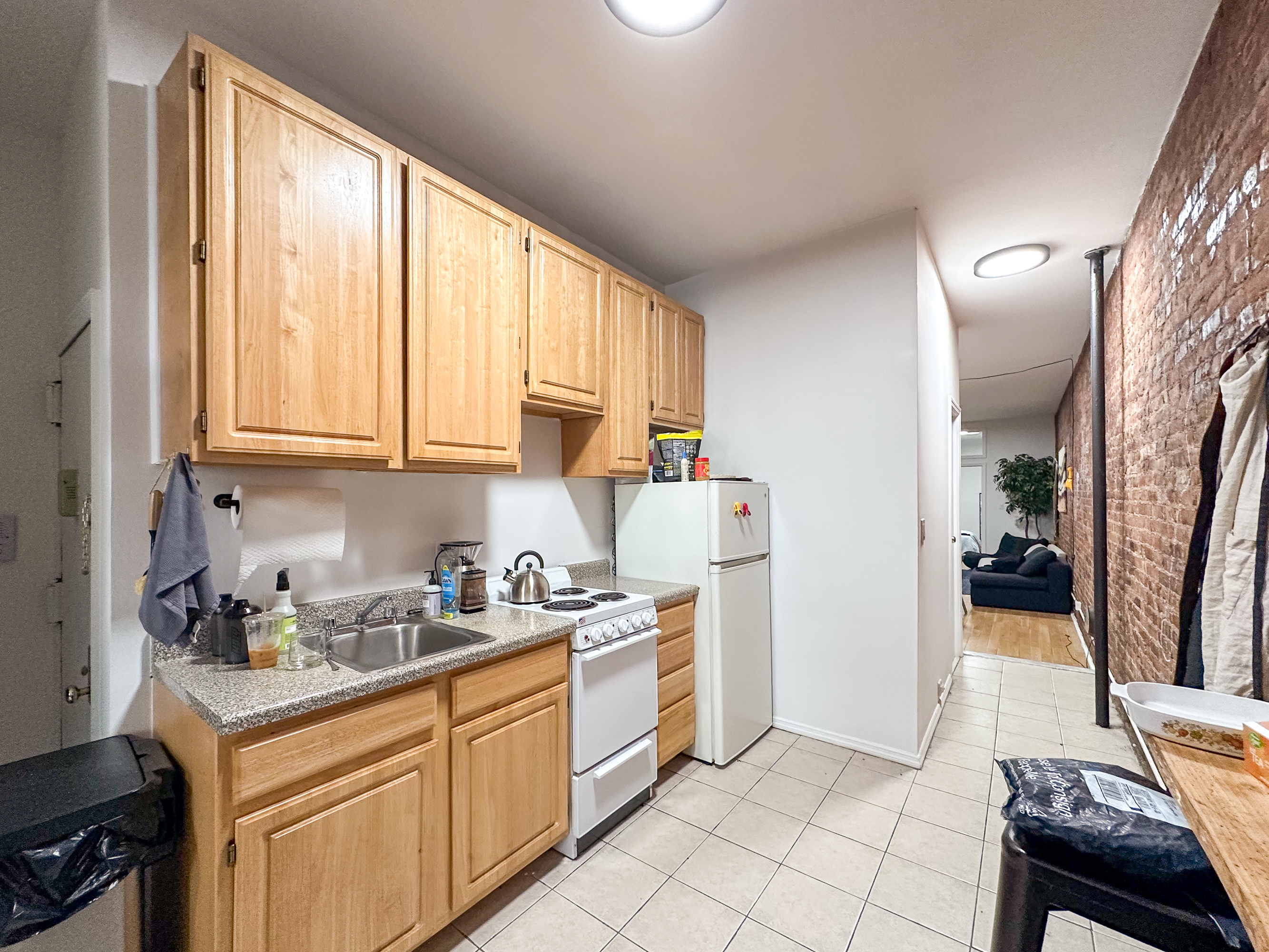 213 East 5th Street, Unit 5 Manhattan, NY 10003 - Photo 8 of 17 a kitchen with a window a sink and a refrigerator
