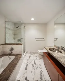 a spacious bathroom with a granite countertop sink a toilet and shower