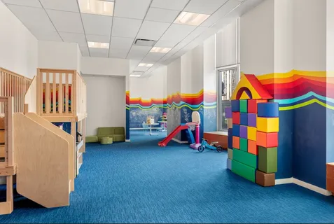 a view of play room with lots of furniture and toys