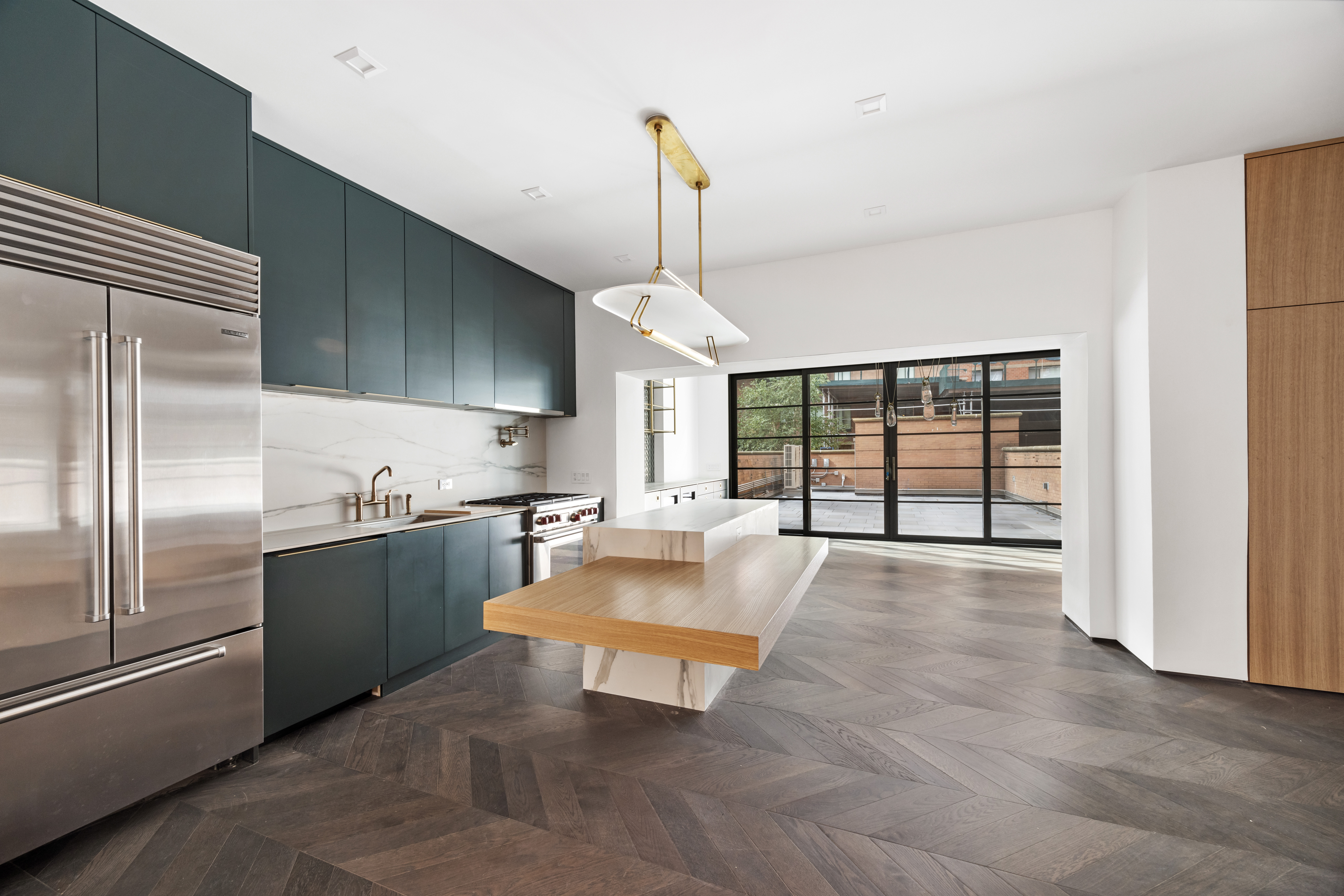 340 Albany Street Manhattan, NY 10280 - Photo 4 of 24 a large kitchen with kitchen island a large counter space and stainless steel appliances