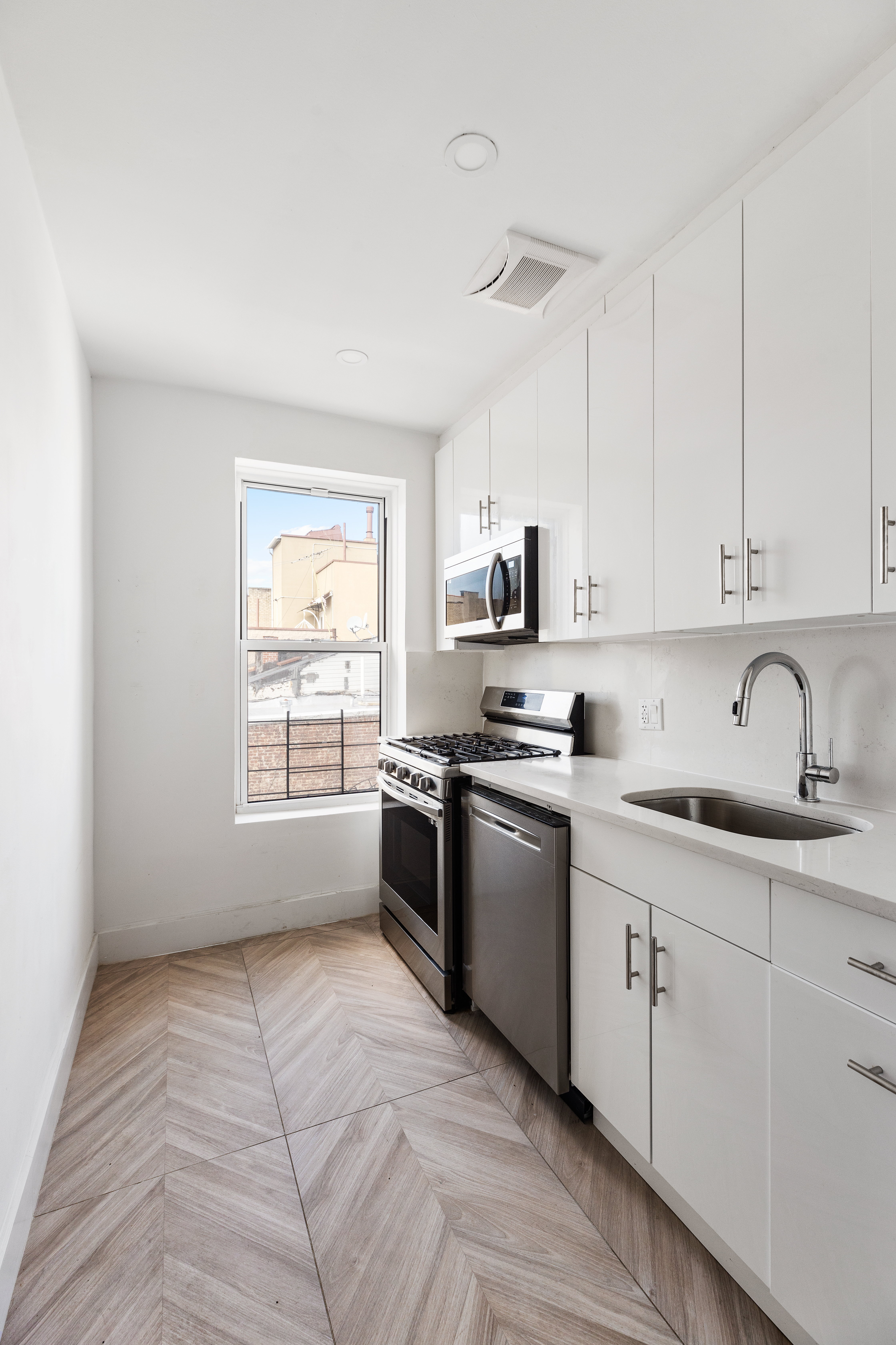 502 5th Avenue, Unit 3 Brooklyn, NY 11215 - Photo 2 of 10 a kitchen with stainless steel appliances granite countertop a stove a sink white cabinets and a window