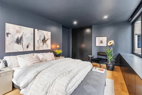 a bedroom with a large bed and a painting on the wall