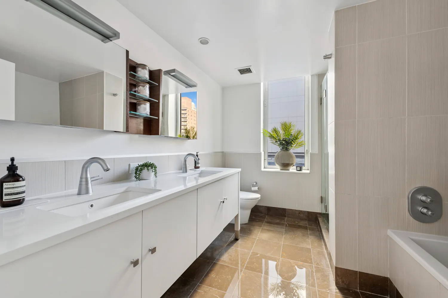 a bathroom with a double vanity sink mirror and toilet