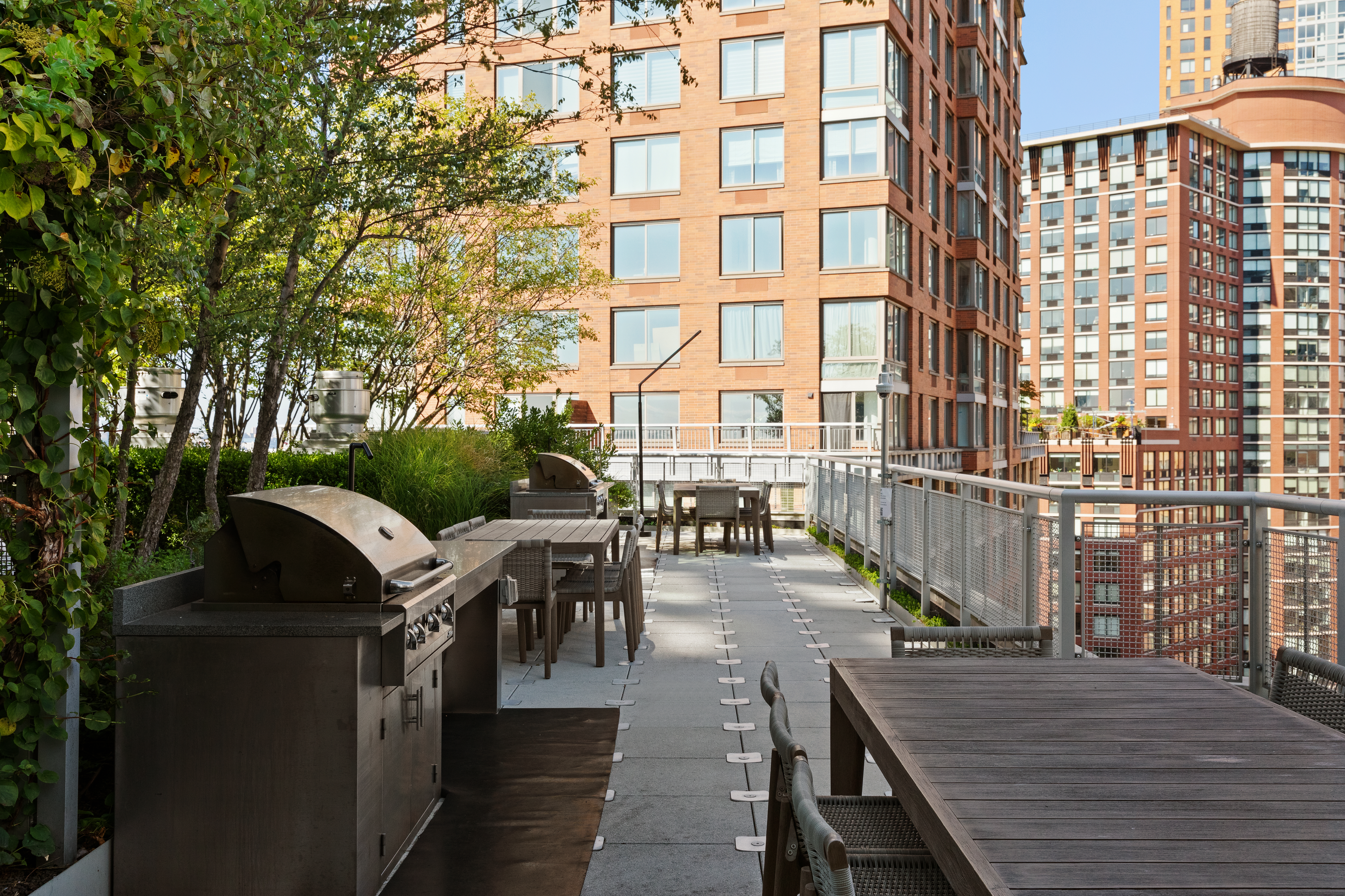 20 River Terrace, Unit 6Q Manhattan, NY 10282 - Photo 6 of 20 a view of a patio with couches table and chairs and potted plants
