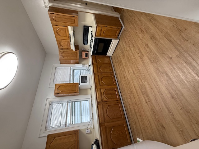 1587 East 18th Street, Unit 2 Brooklyn, NY 11230 - Photo 5 of 13 a kitchen with stainless steel appliances granite countertop a sink and white cabinets with wooden floor