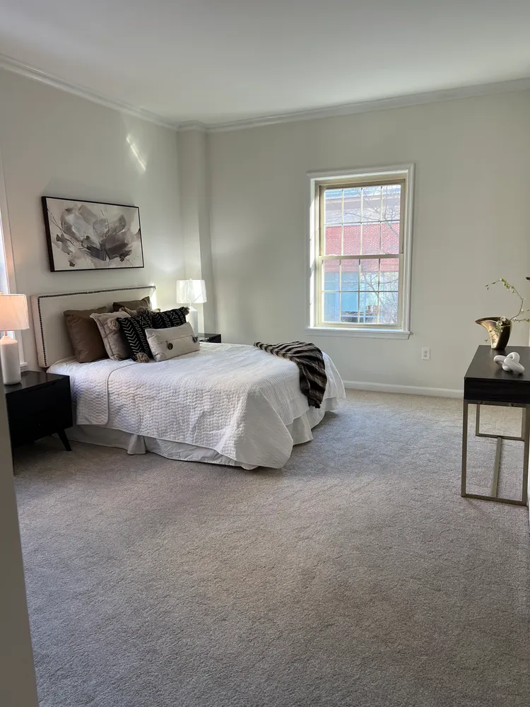 a bedroom with a bed and a painting on the wall