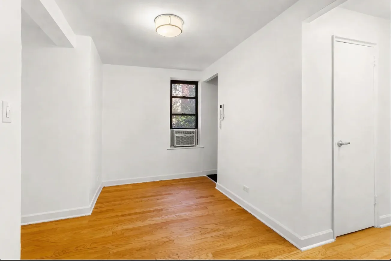a view of empty room with wooden floor