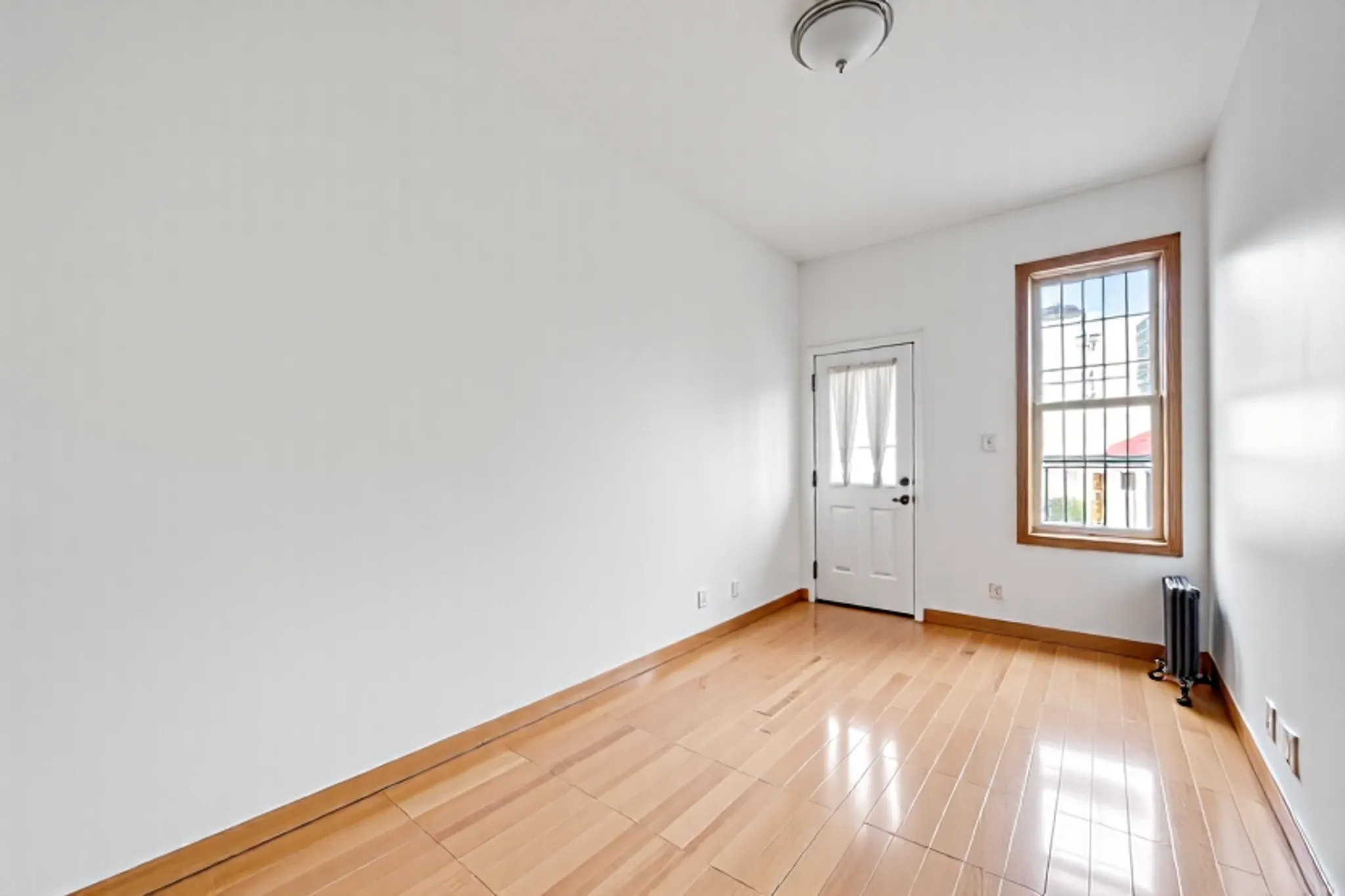 1759 West 1st Street Brooklyn, NY 11223 - Photo 15 of 21 an empty room with wooden floor and windows