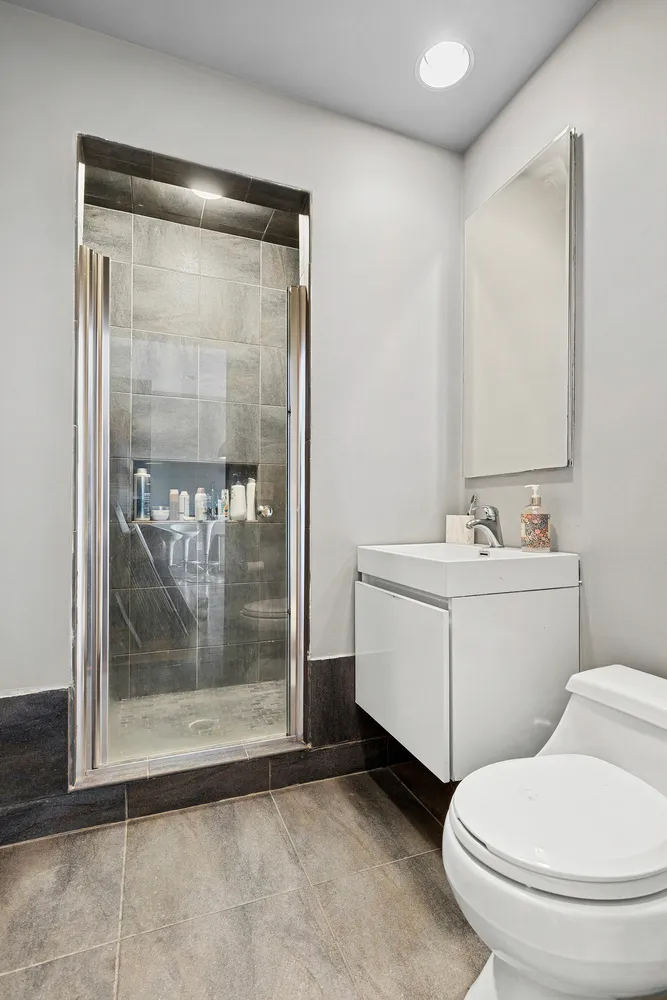 a bathroom with a sink a toilet and shower