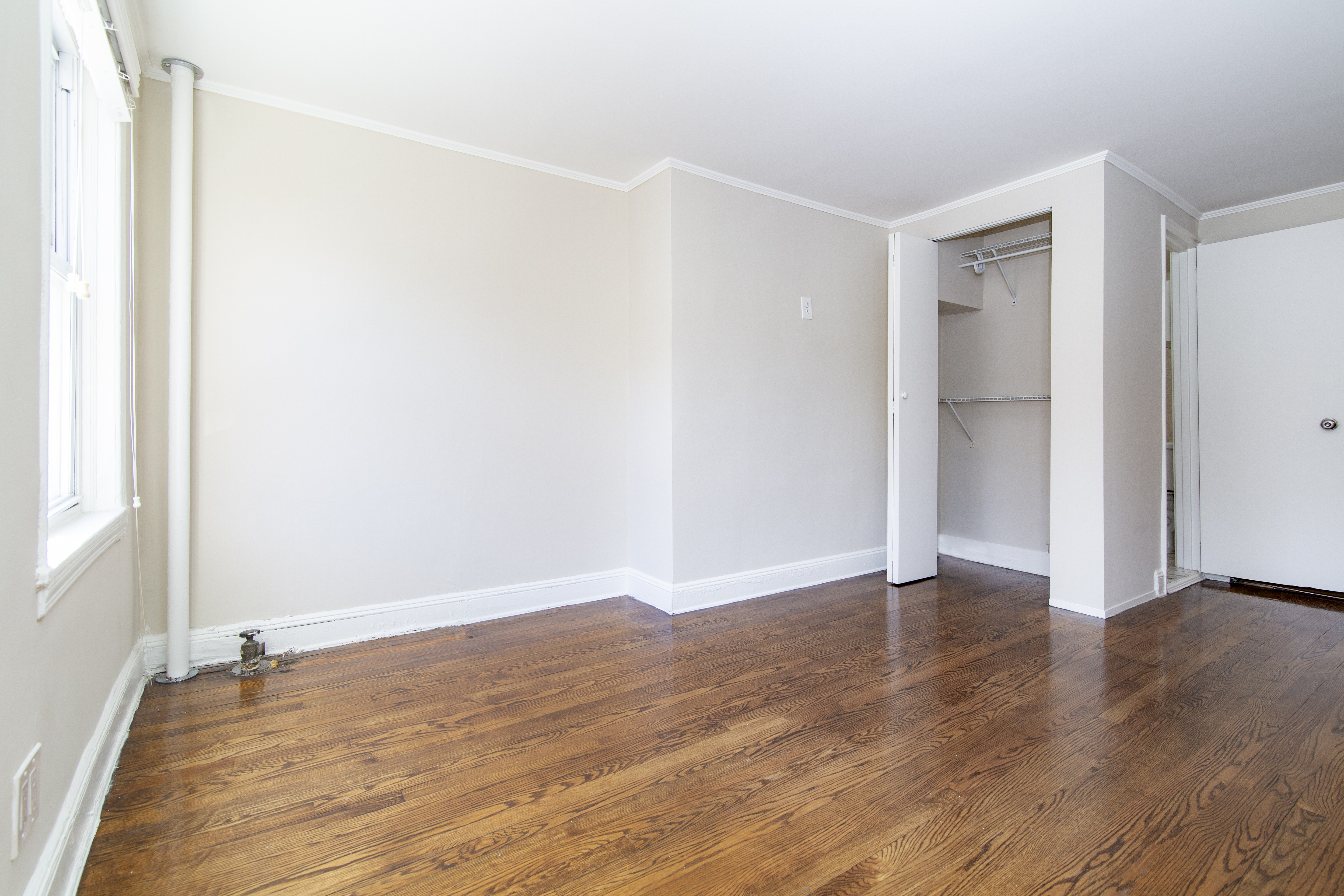 304 Bleecker Street, Unit 3F Manhattan, NY 10014 - Photo 3 of 6 a view of an empty room with wooden floor and a window