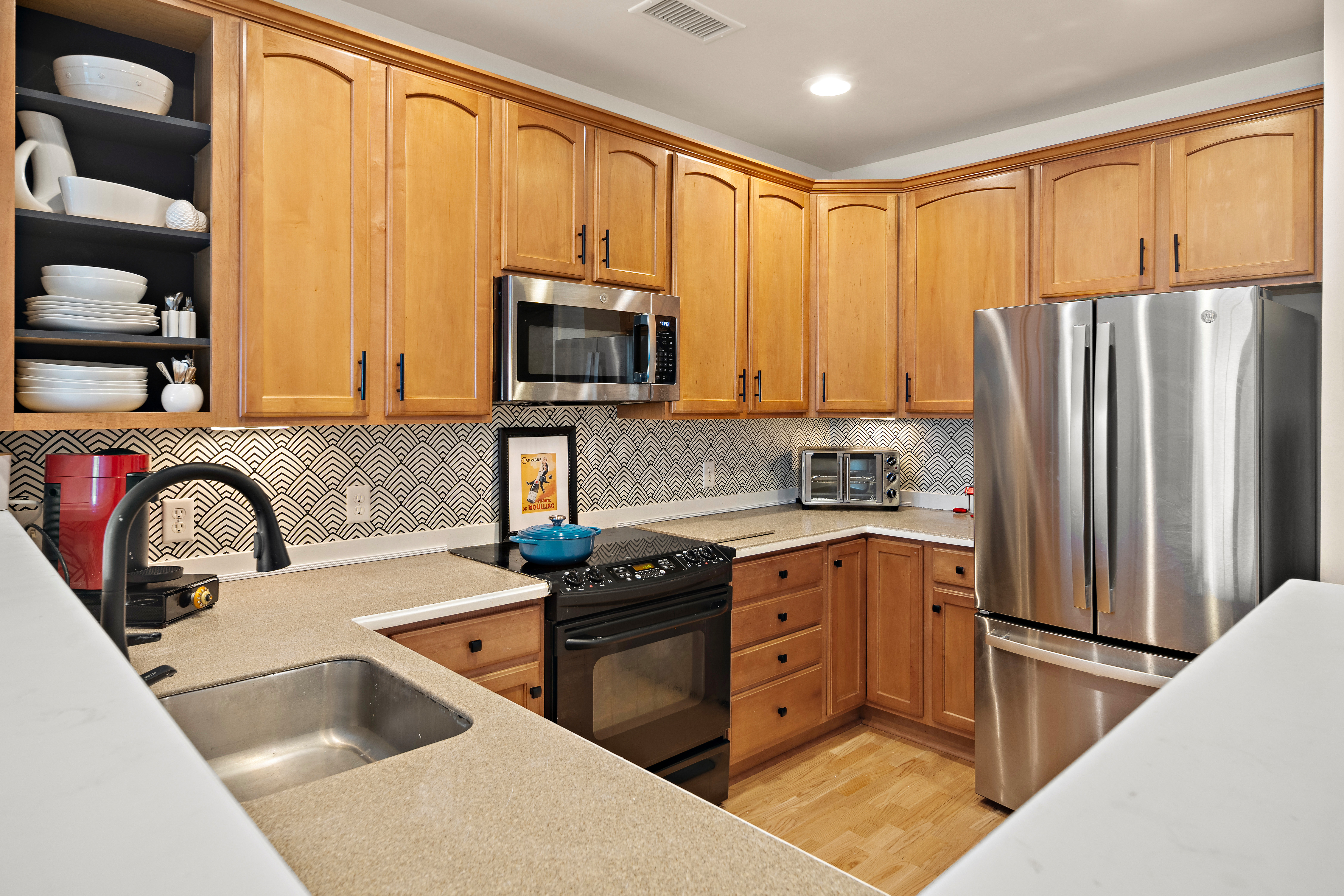 a kitchen with stainless steel appliances granite countertop a refrigerator sink and stove