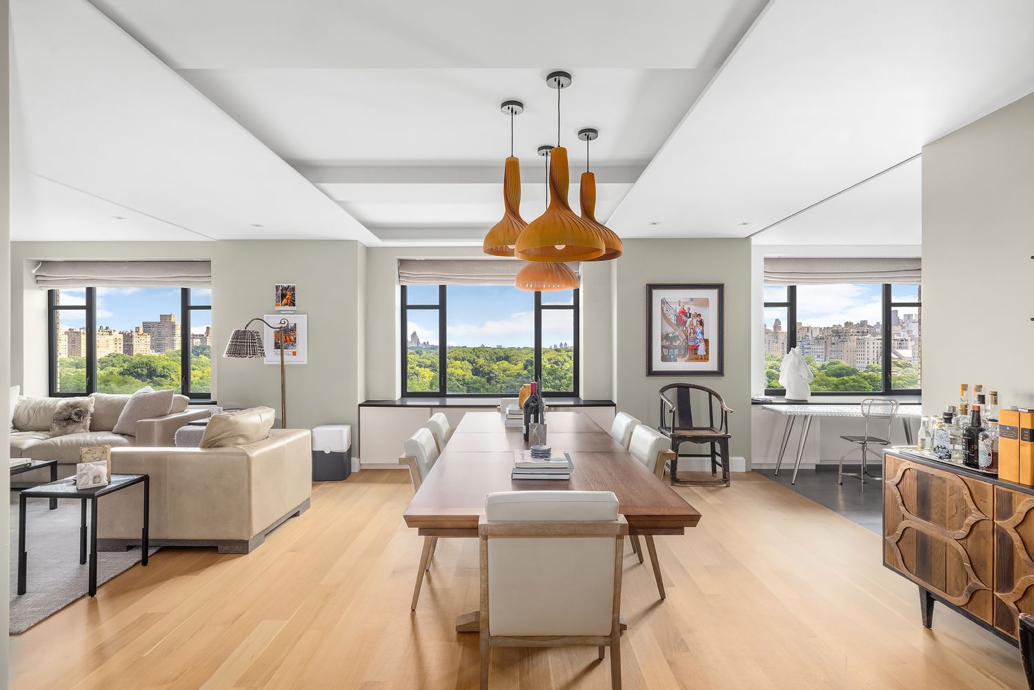a living room with furniture fireplace and large windows
