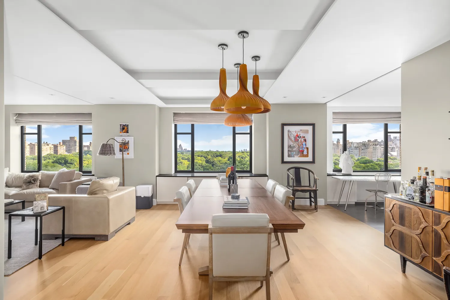 a living room with furniture fireplace and large windows