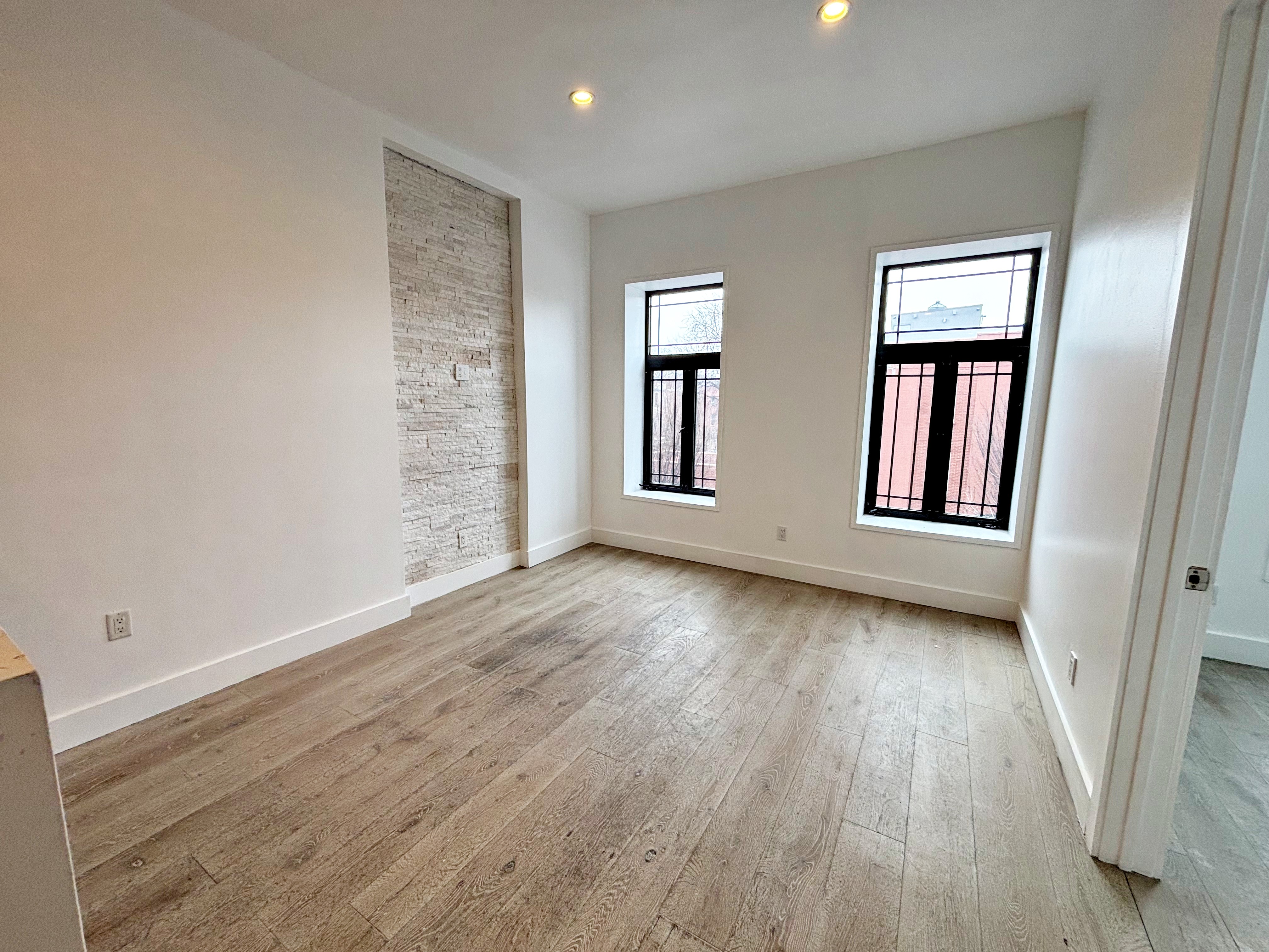 385 Nostrand Avenue, Unit Undisclosed Brooklyn, NY 11216 - Photo 20 of 27 an empty room with wooden floor and windows