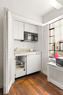 a kitchen with stainless steel appliances a stove and white cabinets
