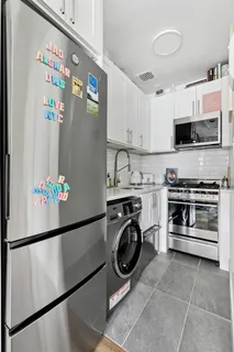 a kitchen with stainless steel appliances granite countertop a refrigerator and a stove top oven