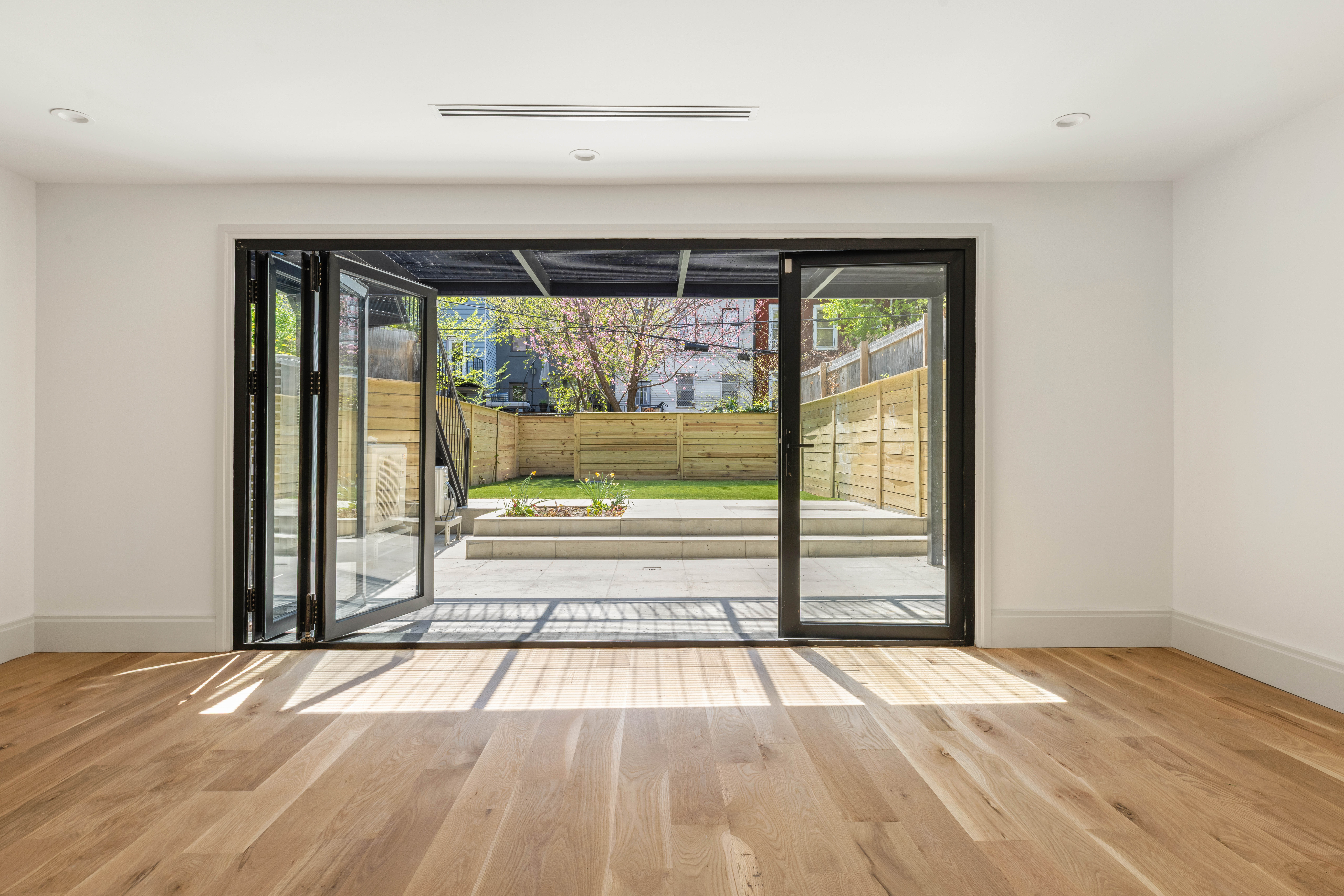 196 Monroe Street Brooklyn, NY 11216 - Photo 18 of 22 a view of empty room with wooden floor and fan