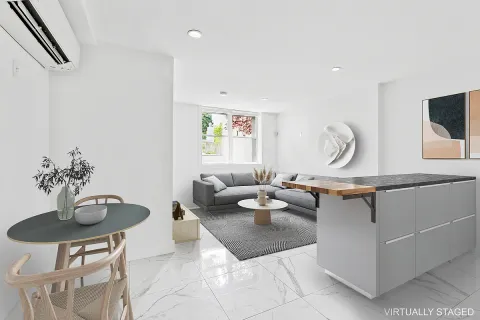 a living room with furniture a window and a potted plant