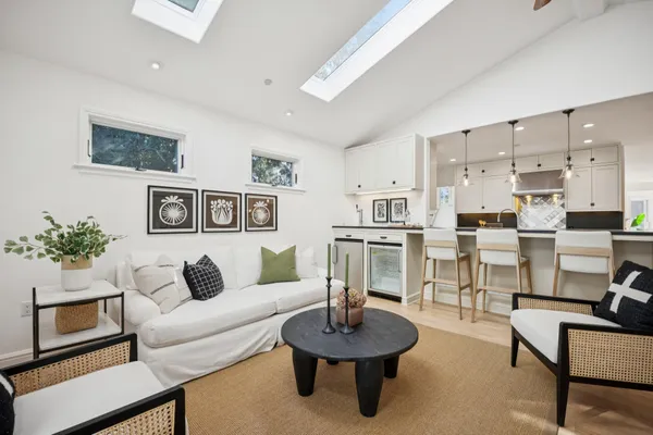 a living room with furniture and a view of kitchen
