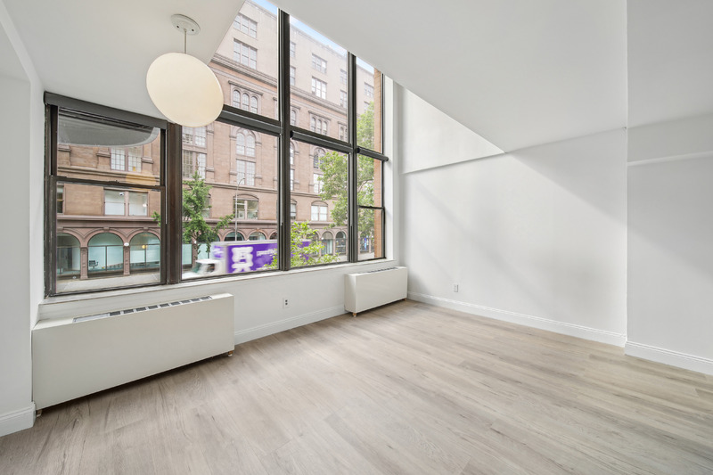 65 Cooper Square, Unit 2A Manhattan, NY 10003 - Photo 3 of 13 an empty room with wooden floor and windows