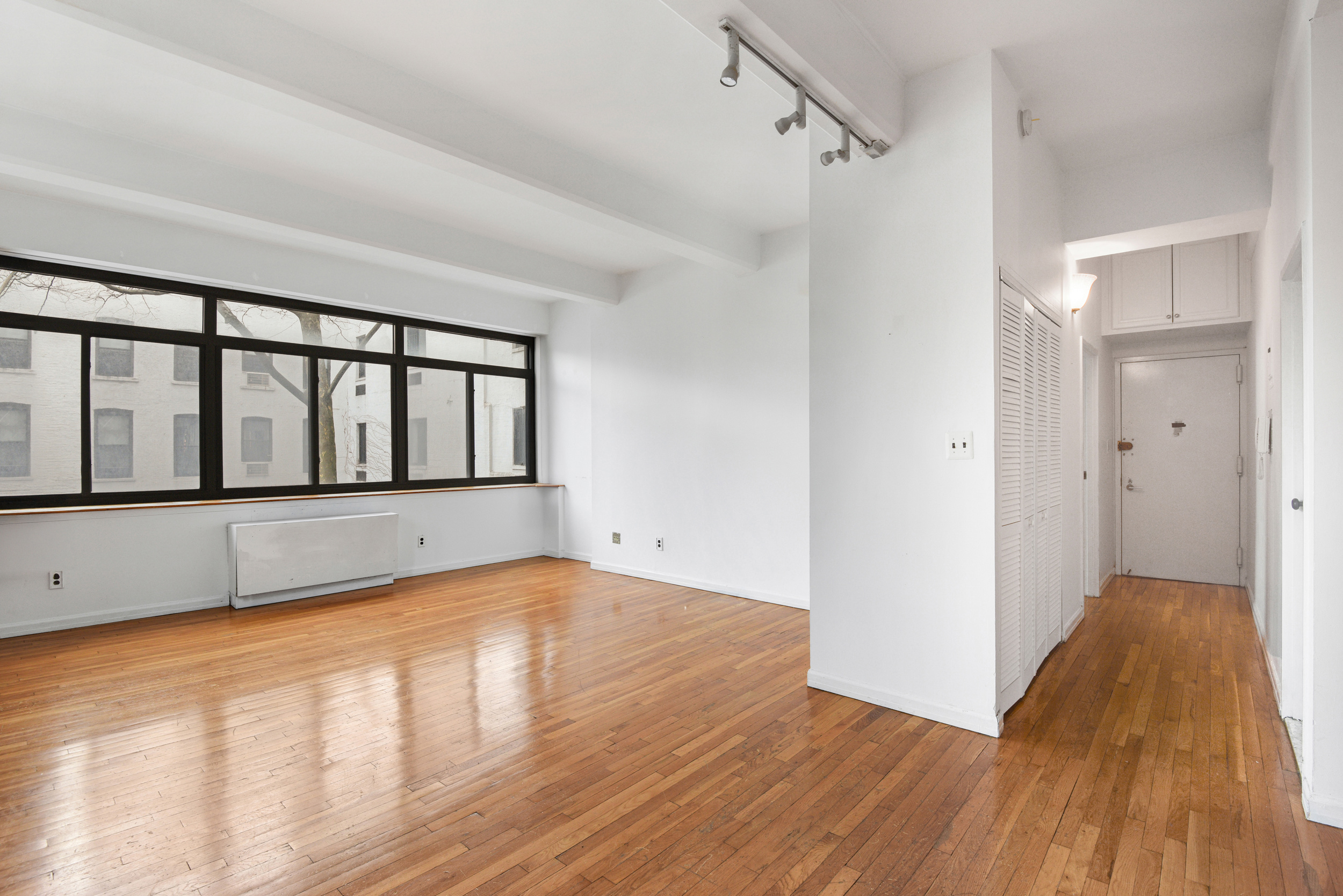 492 Henry Street, Unit 2A Brooklyn, NY 11231 - Photo 3 of 13 a view of an empty room with wooden floor and a window
