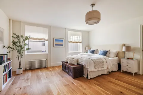 a spacious bedroom with a bed and a dresser
