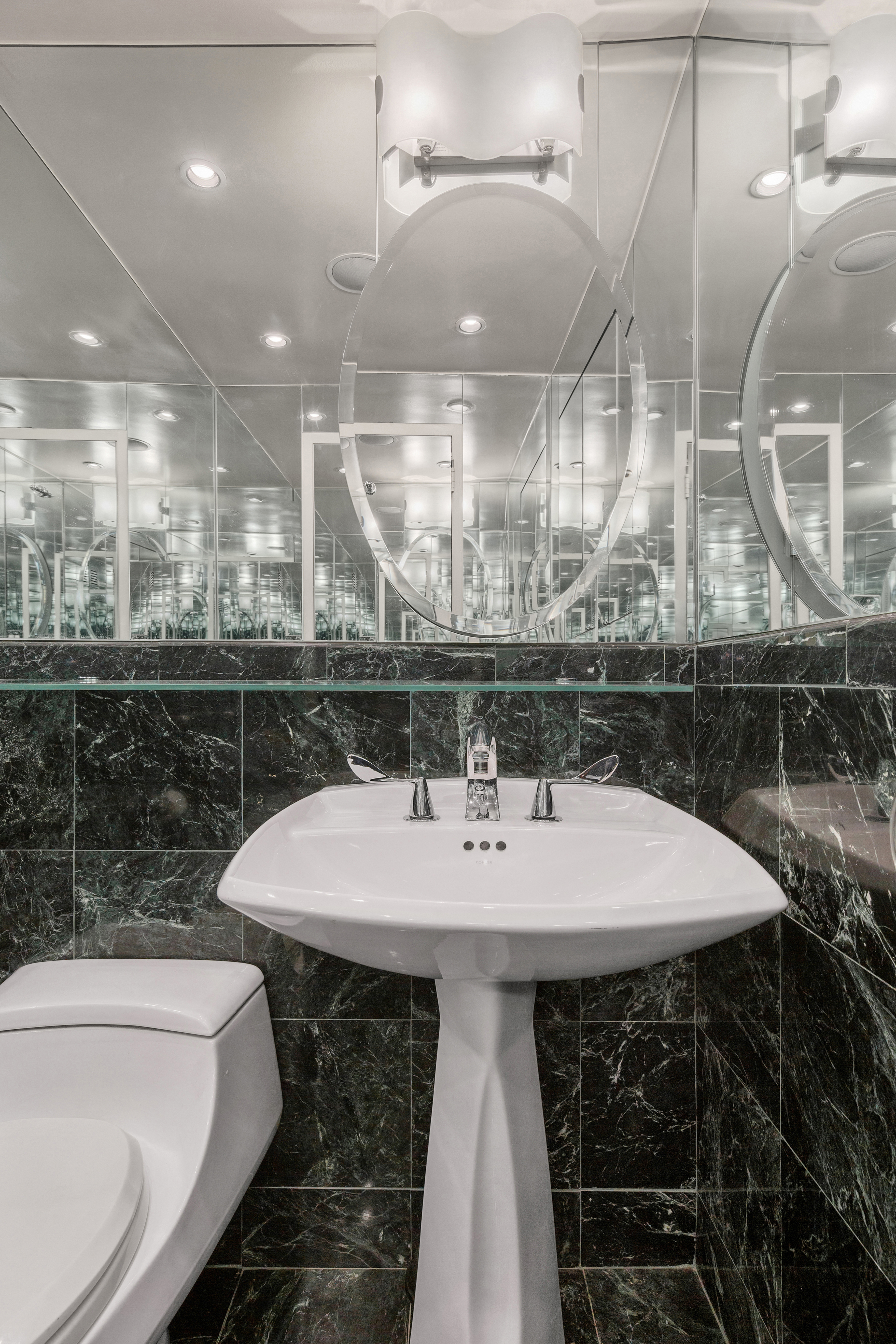 50 Sutton Place South, Unit 9F Manhattan, NY 10022 - Photo 6 of 10 a bathroom with a sink a toilet and a mirror