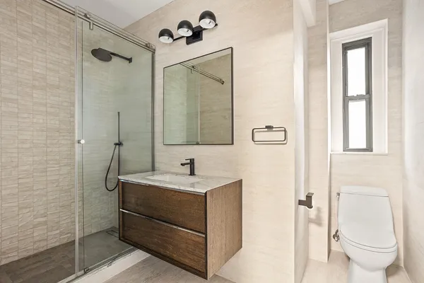 a bathroom with a sink a toilet and shower