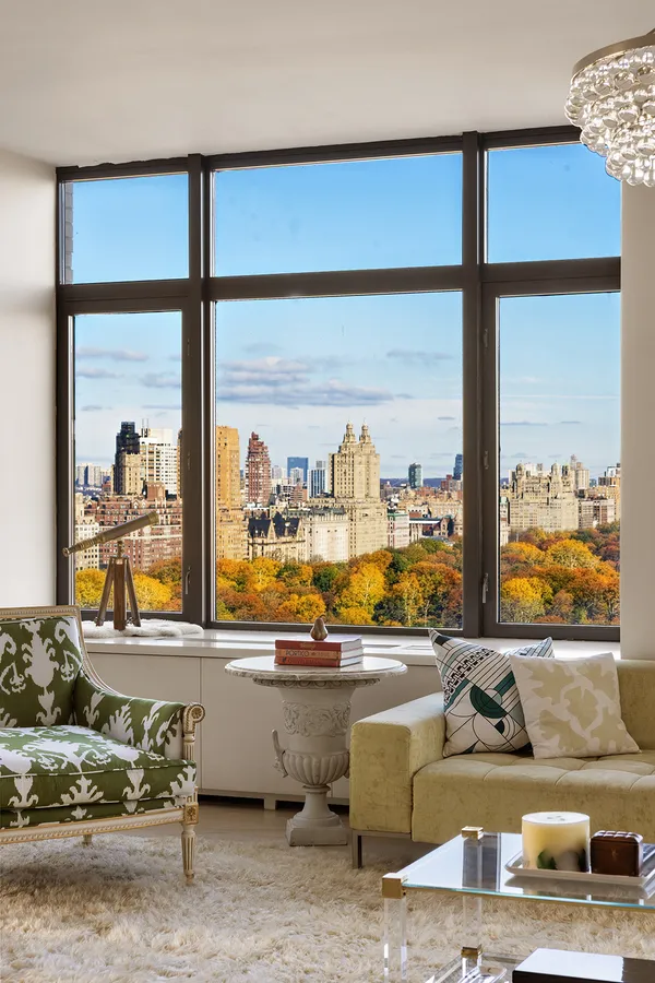 a living room with couch and a floor to ceiling window