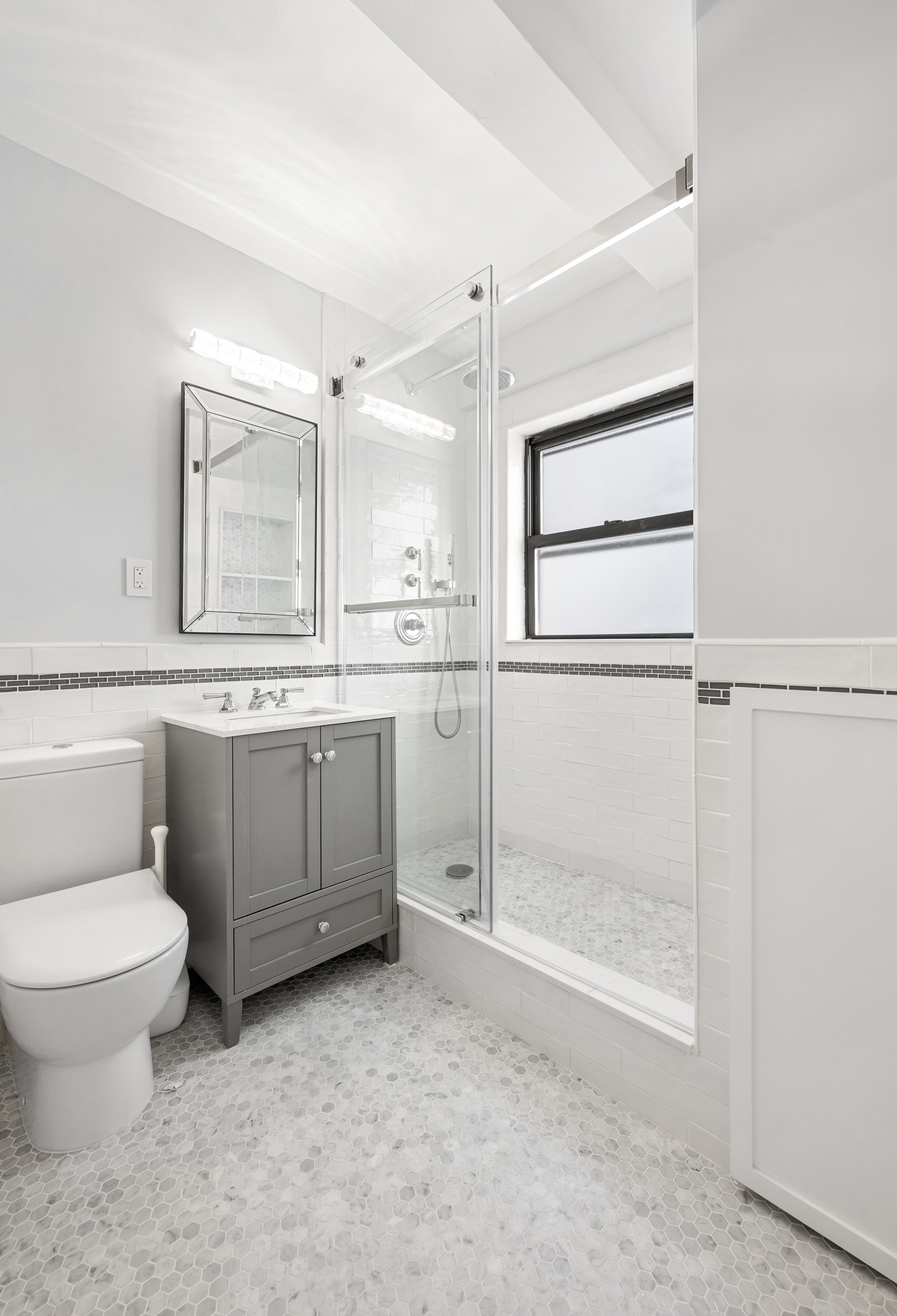 235 East 49th Street, Unit 6G Manhattan, NY 10017 - Photo 12 of 22 a bathroom with a granite countertop toilet sink and mirror