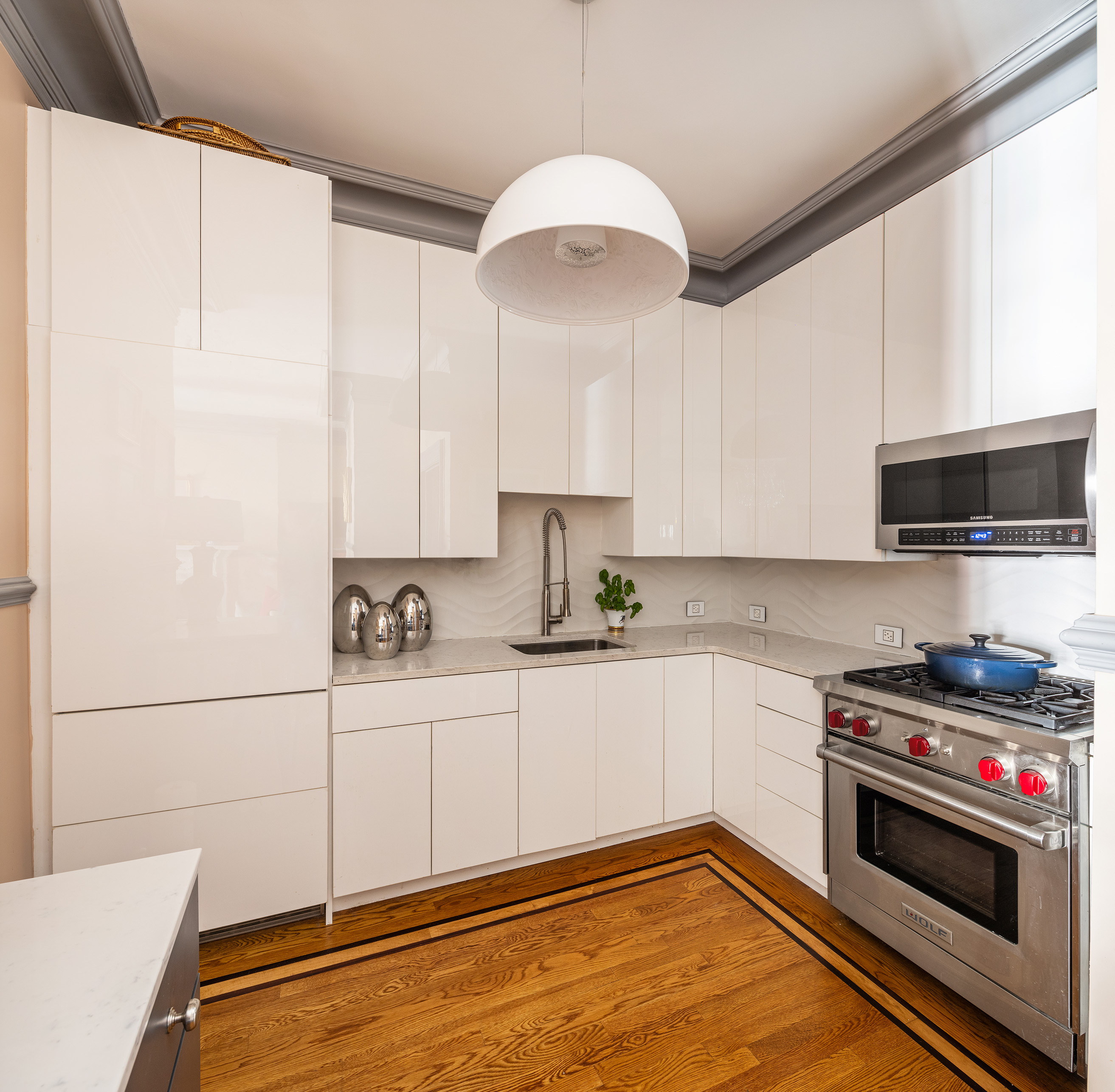 6 East 76th Street, Unit 3F Manhattan, NY 10021 - Photo 4 of 11 a kitchen with stainless steel appliances a stove a sink and a microwave