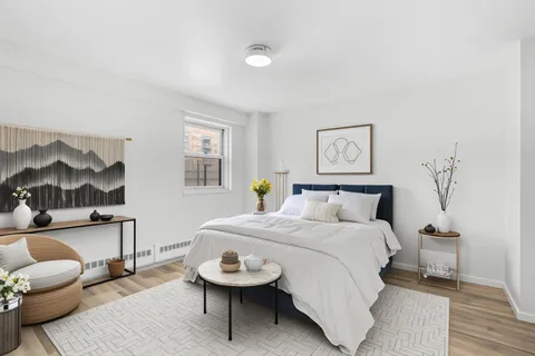 a bedroom with a bed and wooden floor