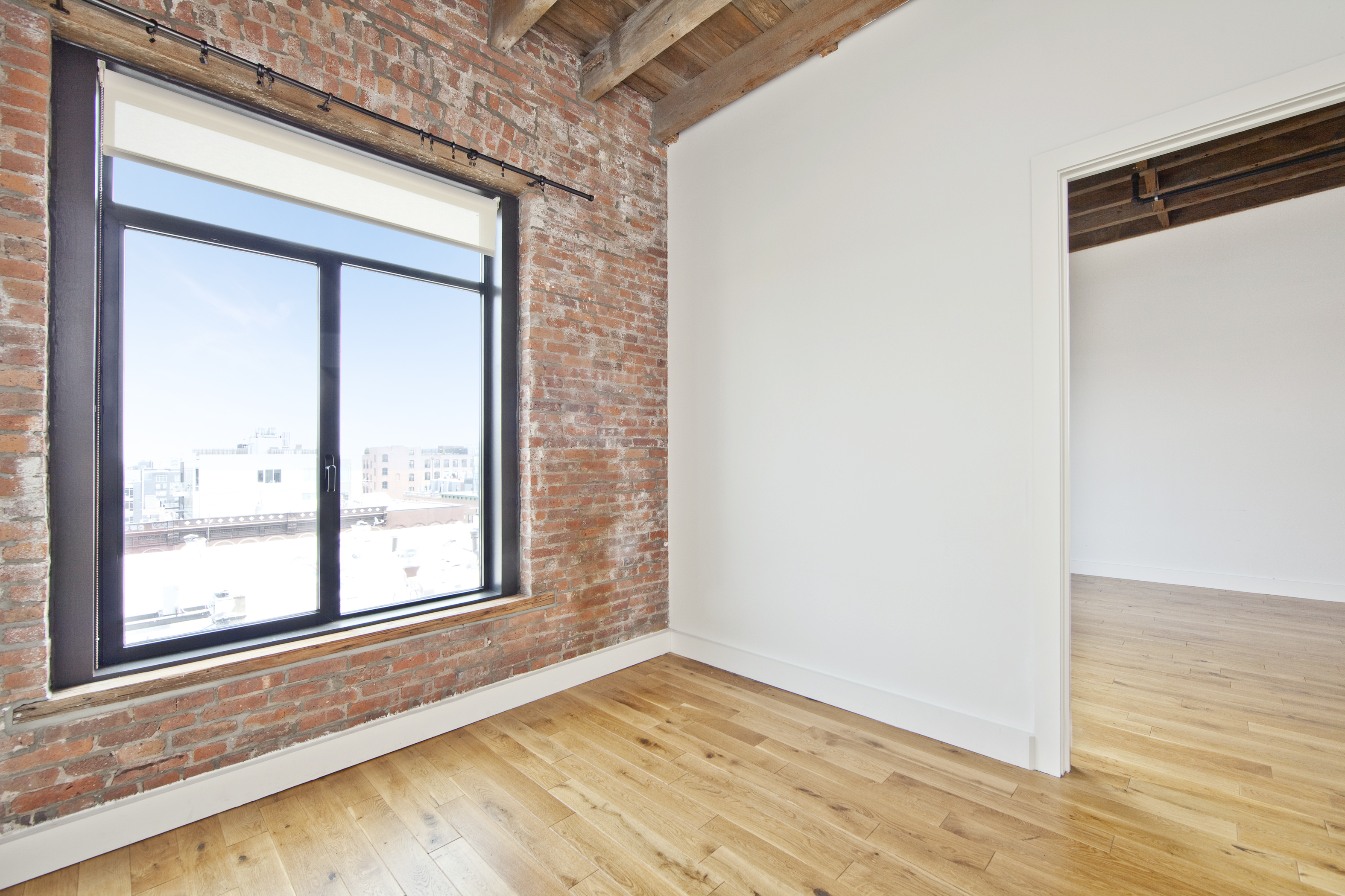 139 North 10th Street, Unit 1G Brooklyn, NY 11249 - Photo 3 of 9 a view of an empty room with wooden floor and a window