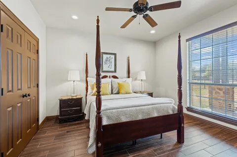 a spacious bathroom with a granite countertop double vanity sink a mirror and a shower