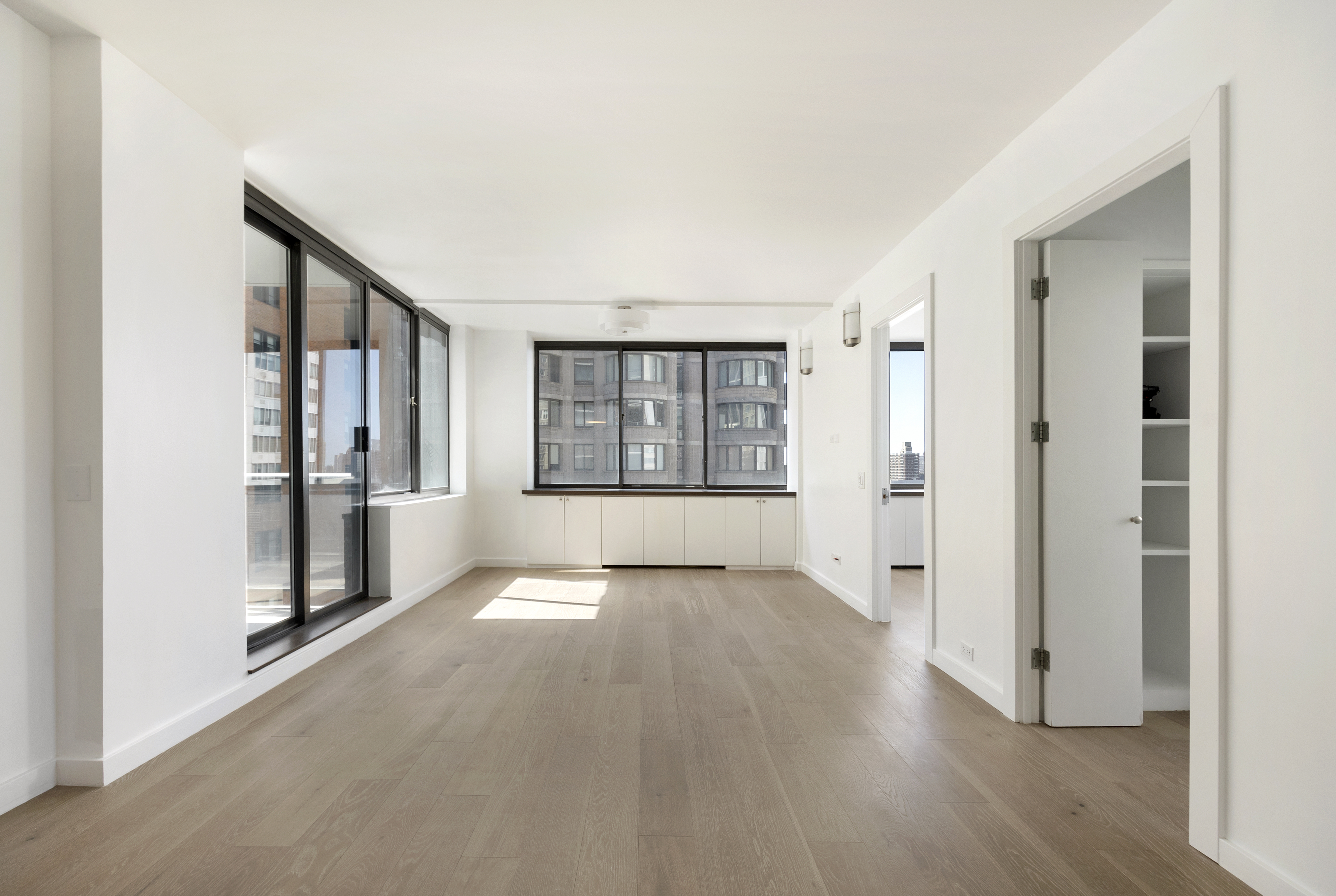 62 West 62nd Street, Unit 18A Manhattan, NY 10023 - Photo 3 of 16 wooden floor in an empty room with a window