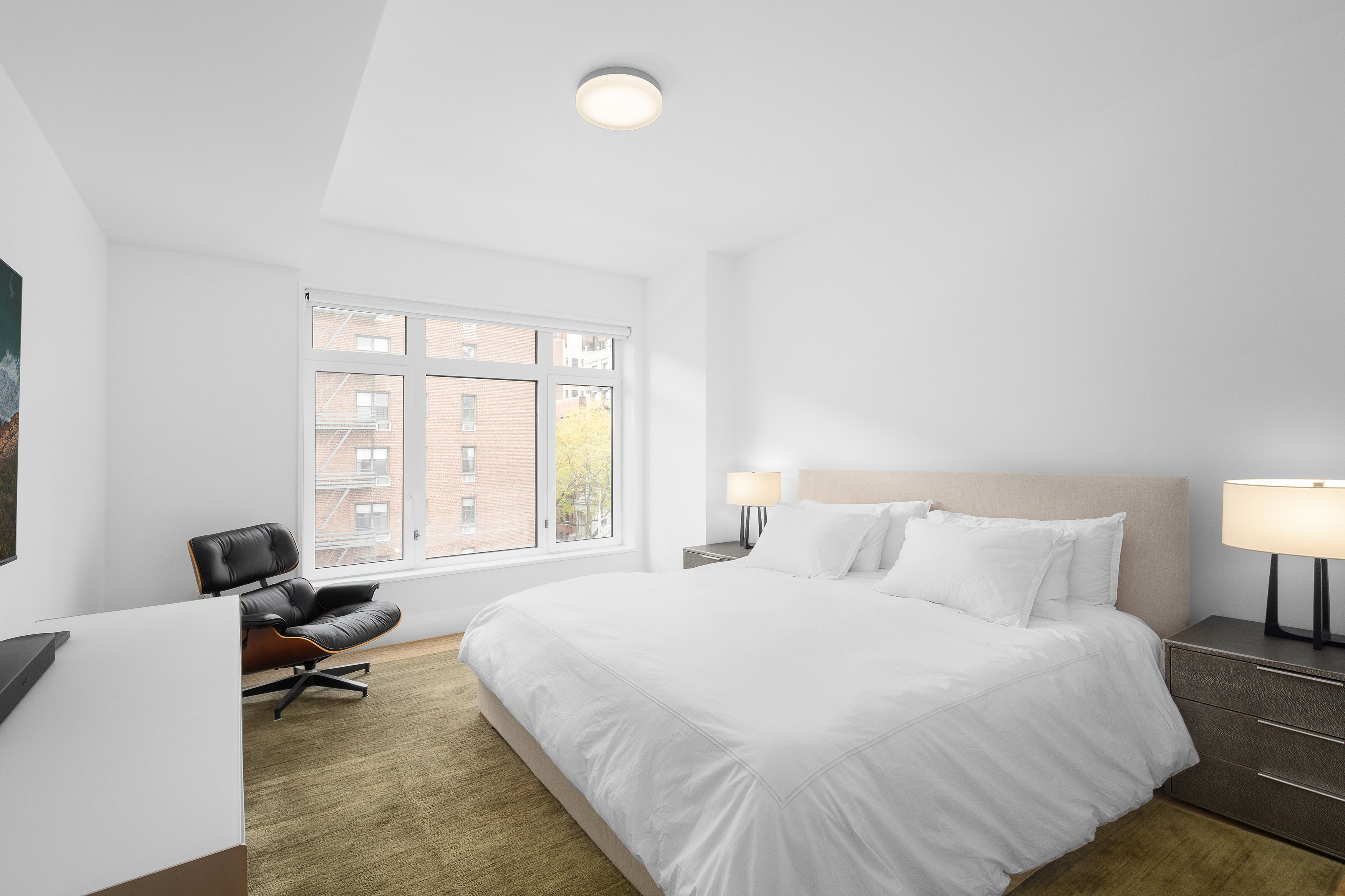 200 East 83rd Street, Unit 5D Manhattan, NY 10028 - Photo 5 of 29 a bedroom with a bed and a couch next to a window