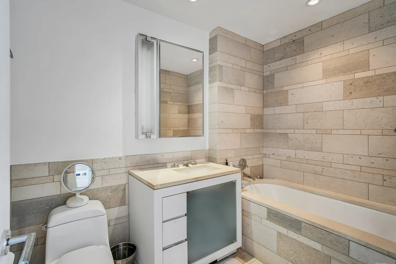 a bathroom with a sink toilet vanity and bathtub