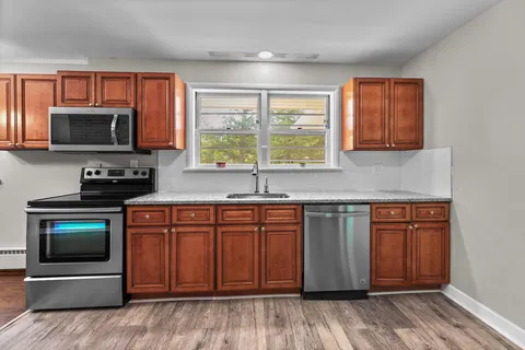 a kitchen with stainless steel appliances granite countertop a stove a sink and a microwave