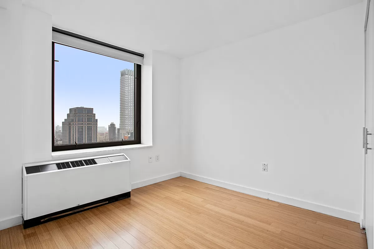 100 West 39th Street, Unit 37E Manhattan, NY 10018 - Photo 4 of 11 a view of an empty room with wooden floor and a wall painting