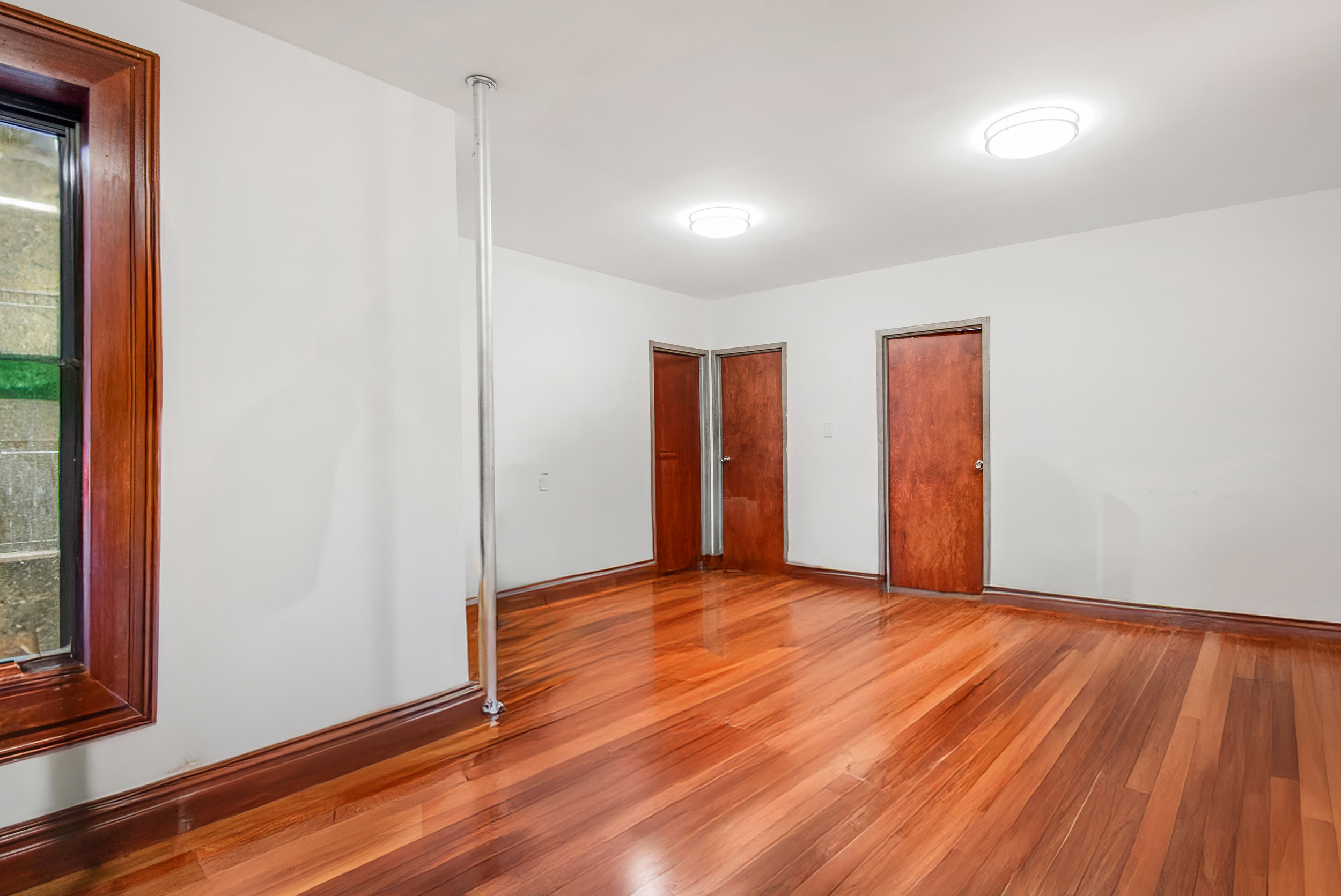 1392 Madison Avenue, Unit 28 Manhattan, NY 10128 - Photo 9 of 10 a view of an empty room with wooden floor and a window