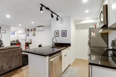 a kitchen with stainless steel appliances granite countertop a sink and a stove